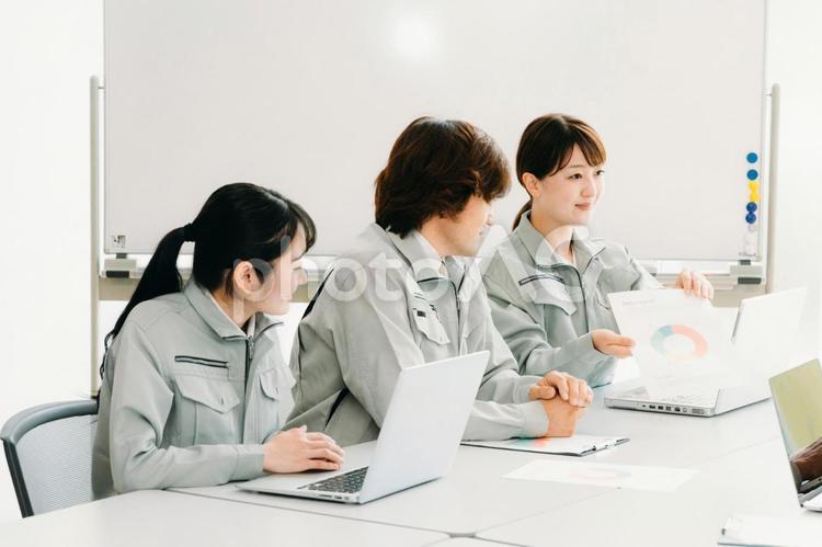 会議をする作業着をきた会社員（提案・3人） 作業服,会議,ビジネスの写真素材