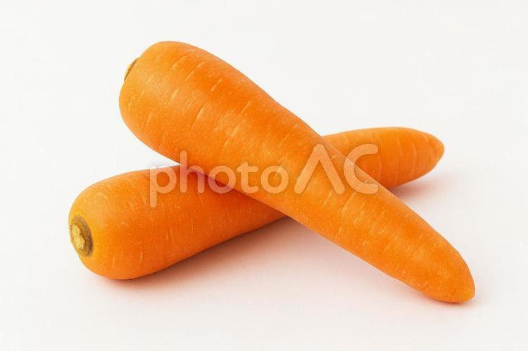 交差して置かれた鮮やかなオレンジの人参 人参,にんじん,野菜の写真素材