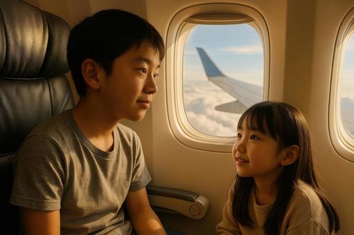 機内で窓の外を眺める日本人兄妹 機内で窓の外を眺める日本人兄妹の写真