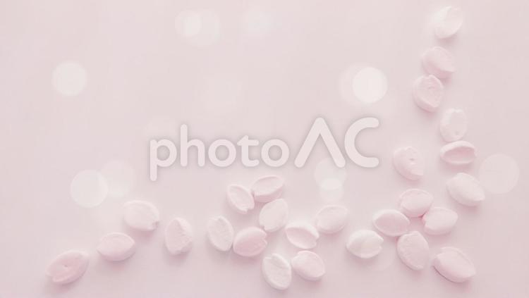 桜の花びらの形のふんわりマシュマロ、キラキラピンクの背景素材 マシュマロ,桜,花びらの写真素材