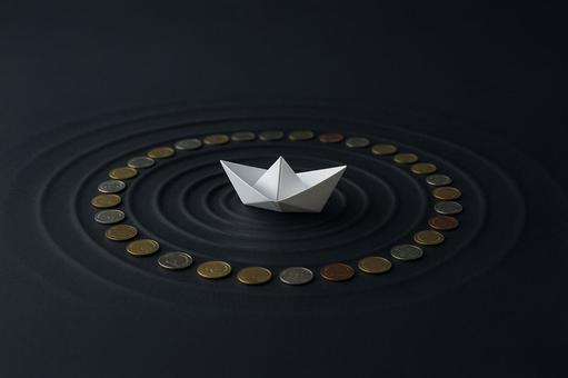 貨幣の環に浮かぶ紙の船 貨幣の環に浮かぶ紙の船の写真