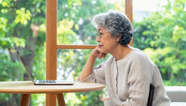 パソコンを使う日本人シニア女性の横顔 パソコンを使う日本人シニア女性の横顔の写真