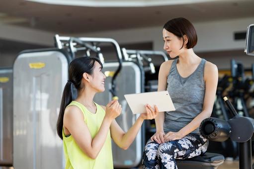 ジムでカウンセリングを受けるミドルの女性 ジム,フィットネス,カウンセリングの写真素材