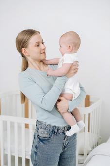 母の首元を触る縦抱きの赤ちゃん 母の首元を触る縦抱きの赤ちゃん 女性,赤ちゃん,かわいいの写真素材