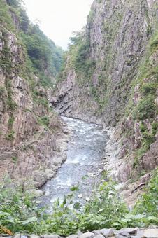 清津峡の清流と巨大な岩壁と柱状節理の断崖 清津峡の清流と巨大な岩壁と柱状節理の断崖の写真