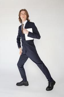 歩くポーズでタブレットを抱えるスーツの男性 男性,外国人,欧米人の写真素材