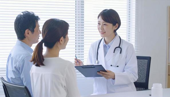 患者女性に説明する日本人医師 患者女性に説明する日本人医師の写真