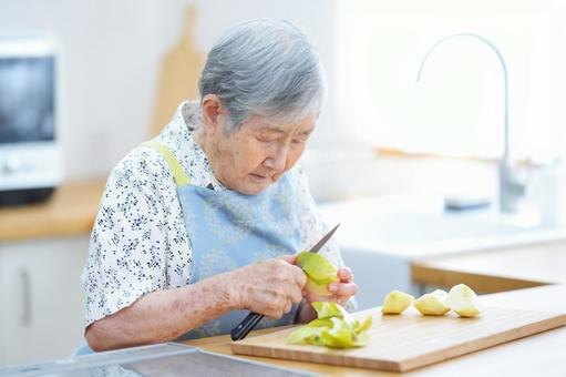 リンゴの皮を剥く高齢女性 女性,リンゴ,皮むきの写真素材