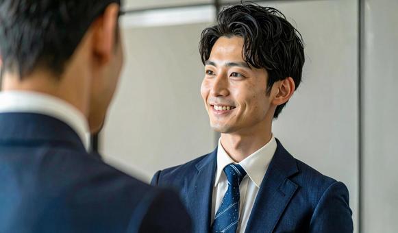 笑顔で話すスーツ姿の男性 笑顔で話すスーツ姿の男性の写真