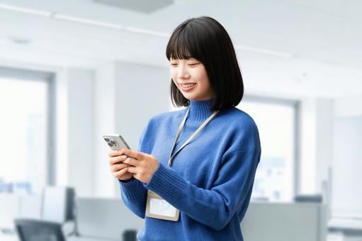 スマホを使う笑顔の女性・ビジネスウーマン 女性,スマホ,スマートフォンの写真素材