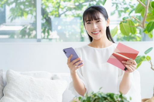 リビングで貯金通帳を見る若い女性 リビングで貯金通帳を見る若い女性 女性,リビング,ライフスタイルの写真素材