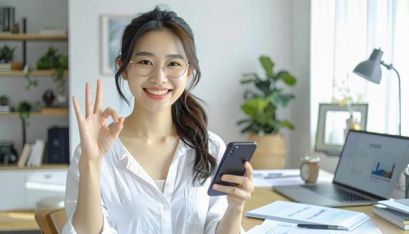 家計がうまくいきスマホ片手に微笑む女性 家計がうまくいきスマホ片手に微笑む女性の写真