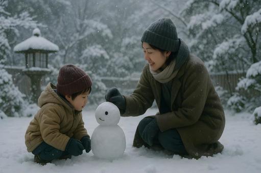 雪だるまを作る親子の写真