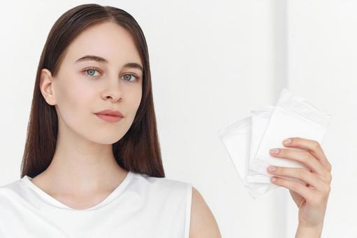 生理用ナプキンを持っているカメラ目線の女性 生理,月経,女性の写真素材