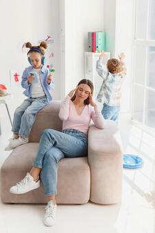 リビングで頭痛に悩まされる女性 親子,女性,頭痛の写真素材