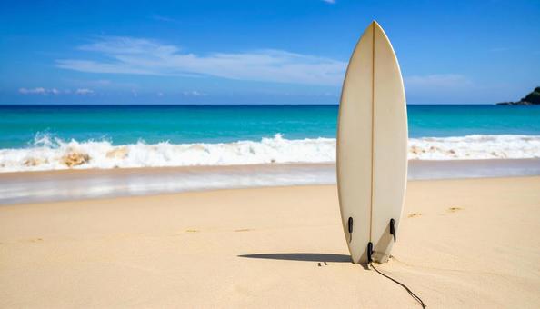 白い砂浜に刺さるサーフボード２の写真