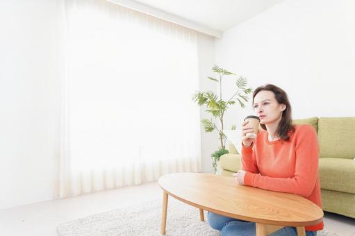 家でコーヒーを飲む若い女性 ホットコーヒー,一人暮らし,ぼーっとするの写真素材