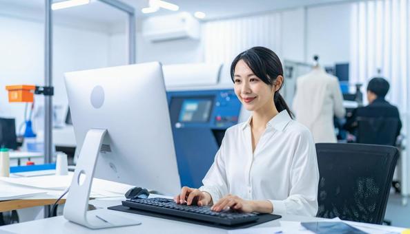 工場の三次元測定機を使う作業服の女性の写真