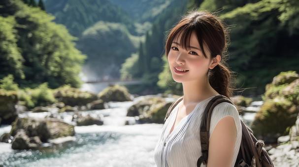 夏の渓流沿いの遊歩道に立つ若い日本人女性の写真