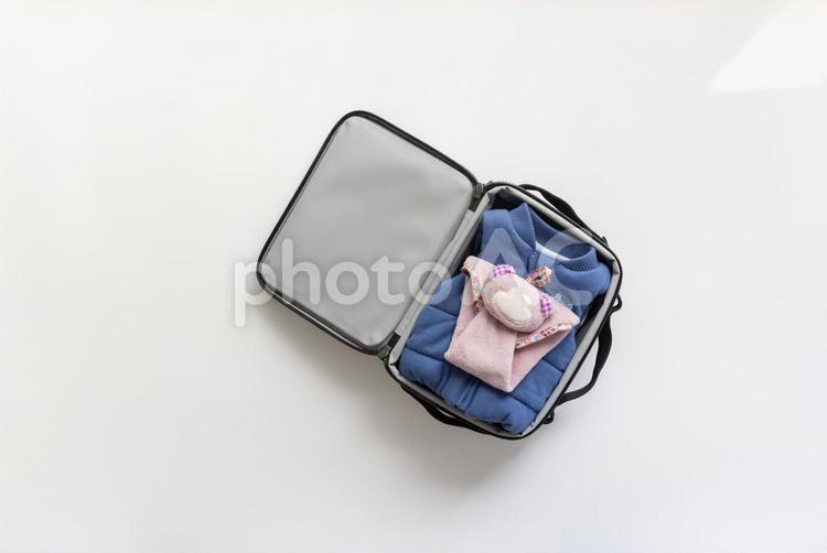旅行バッグを開いたらベストとぬいぐるみがある様子 旅行バッグ,ダウン,ベストの写真素材
