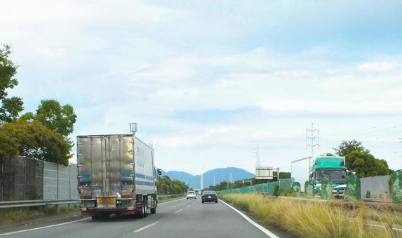 トラックが上り下りを走る東名高速道路 トラックが上り下りを走る東名高速道路 車,トラック,フェンスの写真素材