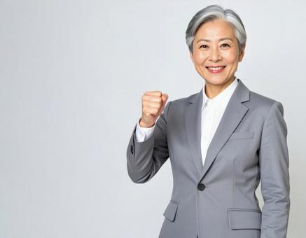 ガッツポーズをするスーツの白髪の女性 ガッツポーズをするスーツの白髪の女性の写真