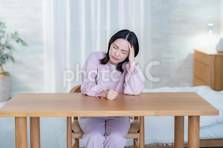 椅子に座り頭をおさえる女性 不眠,若い,寝不足の写真素材