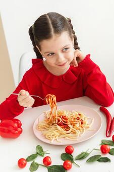 パスタをフォークで巻き横を見る女の子 女の子,パスタ,頬杖の写真素材