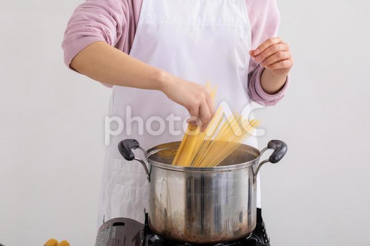 パスタを茹でる女性　Cooking パスタ,料理,エプロンの写真素材