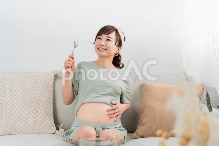 スプーンとフォークを持つ日本人の妊婦 妊婦,肥満,大食いの写真素材