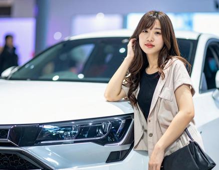 車の横でポーズを取るキャンペーンガール 車の横でポーズを取るキャンペーンガールの写真