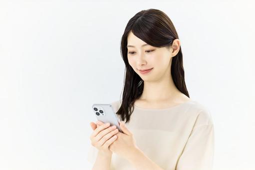 スマートフォンを操作する女性 スマートフォンを操作する女性 女性,スマホ,スマートフォンの写真素材