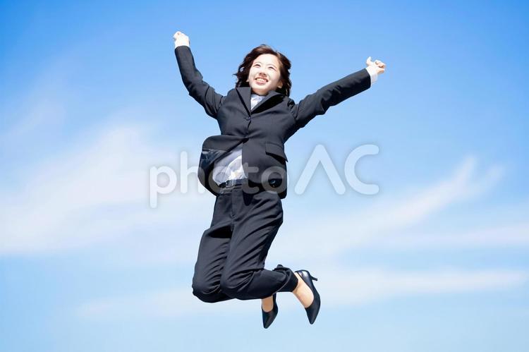青空にジャンプする就活生・新入社員の女性 女性,ビジネス,就活の写真素材