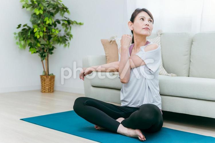部屋でヨガをするミドル世代の女性 ヨガ,ピラティス,筋トレの写真素材