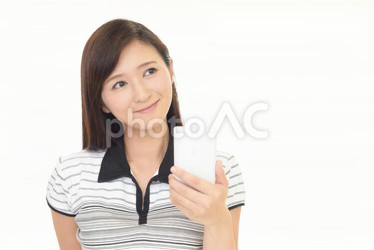 スマートフォンを持つ笑顔の女性 女性,スマートフォン,女の写真素材