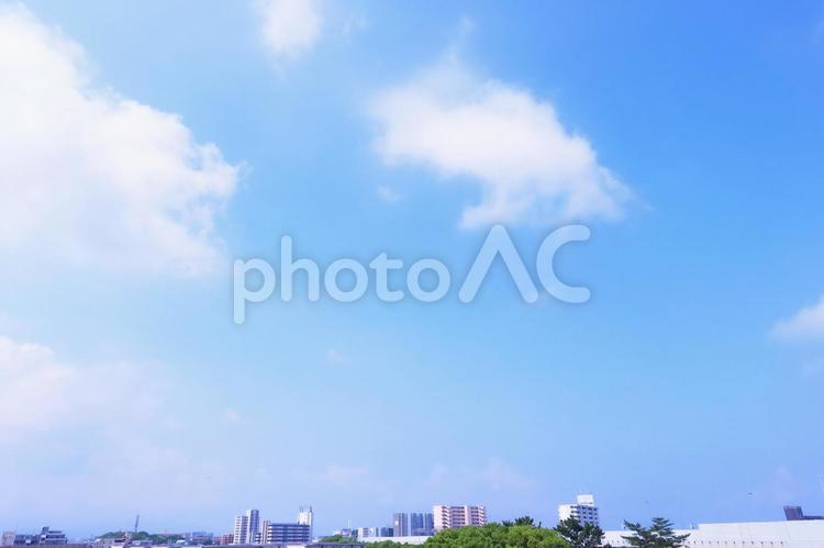 青空に浮かぶ雲と街並みのある空の背景 空,青空,背景の写真素材