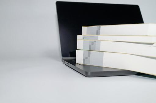 積まれた書籍の側面とノートパソコン 本,ノートパソコン,学習の写真素材