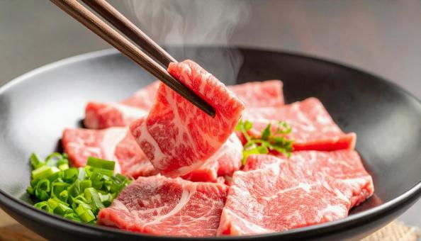 焼肉用の生肉を箸でつまむ 焼肉用の生肉を箸でつまむの写真