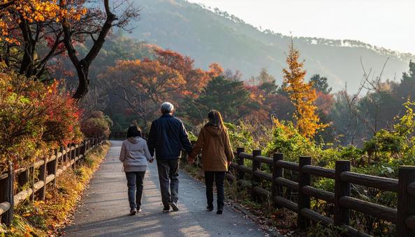 なごやかな雰囲気で森林を歩く家族の後ろ姿の写真