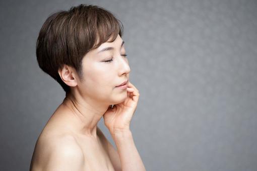 A middle-aged Japanese woman who puts her hand on her cheek and turns to the side, japonais, fem, moyen âge, JPG