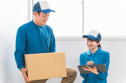 段ボールを持つ引越し業者・配達員の男女 段ボールを持つ引越し業者・配達員の男女 配達,引越し,タブレットの写真素材