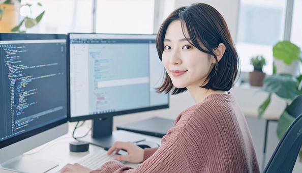 プログラミングをする女性エンジニア プログラミングをする女性エンジニアの写真
