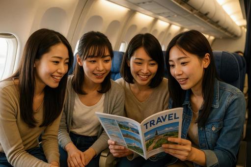 機内で旅行プランを話し合う女子旅グループ 機内で旅行プランを話し合う女子旅グループの写真