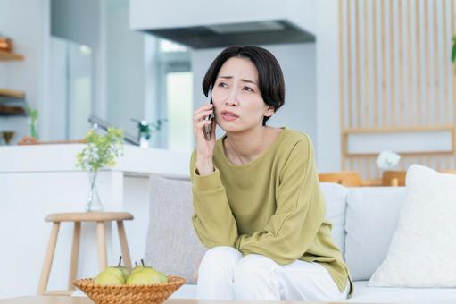 電話で悩むミドルの女性 電話で悩むミドルの女性の写真
