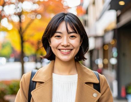 秋の街を歩く笑顔の女性 秋の街を歩く笑顔の女性の写真