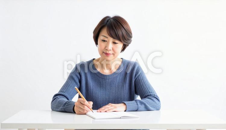 ノートに文字を鉛筆でしたためる40代女性 文字,書く,記録の写真素材