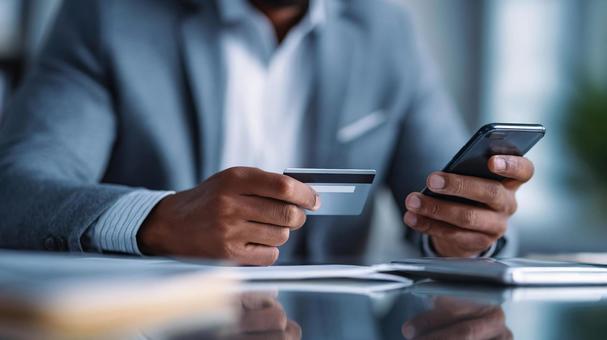 カードとスマホを持つビジネスマン01の写真