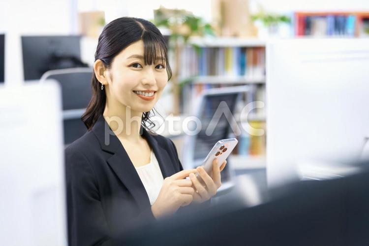 スマホ　ビジネスウーマン　笑顔　オフィス スマホ,ビジネスウーマン,ビジネスシーンの写真素材