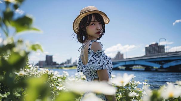 河原でストローハットとワンピースの女性 河原でストローハットとワンピースの女性の写真