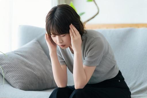 A woman holding her head in distress, JPG A woman holding her head in distress, JPG